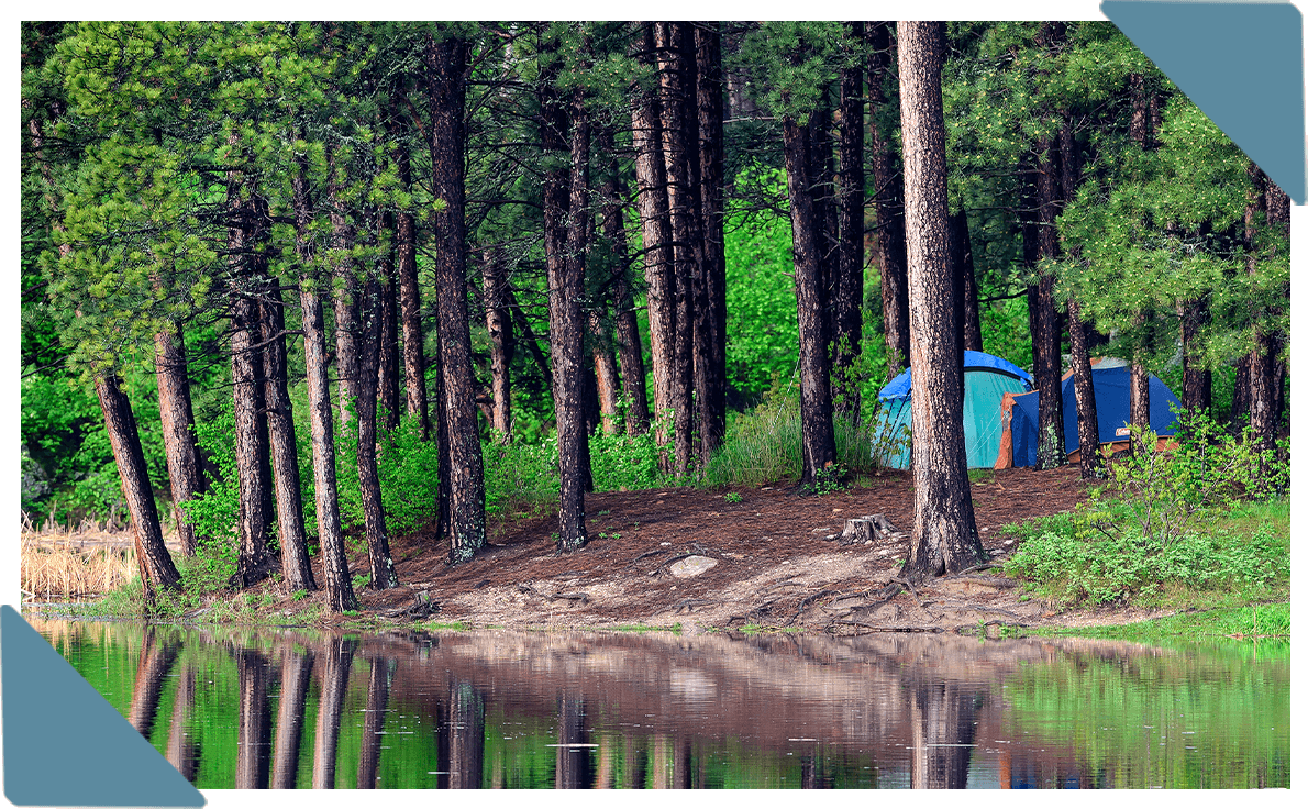 A photo of a camping tents by a lake.