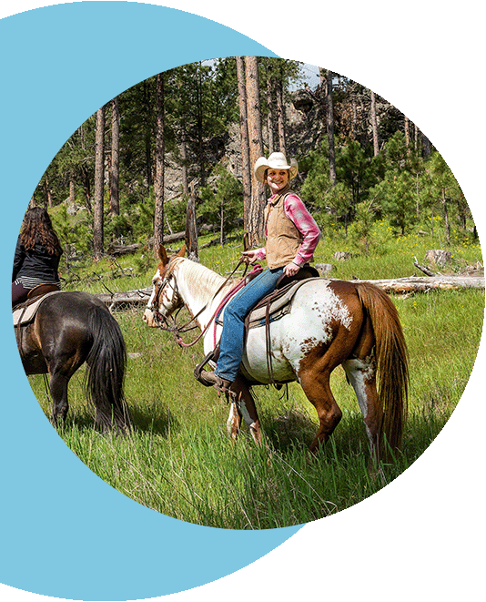 A group riding through Sica Hollow State Park on horseback.