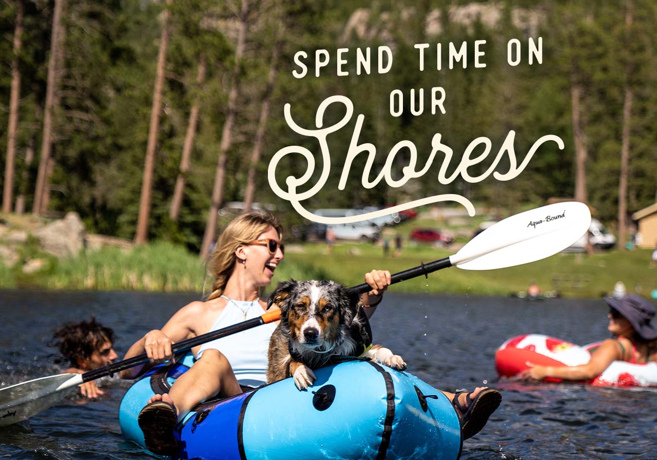 Spend Time On Our Shores - A woman and her dog kayaking in a South Dakota lake.