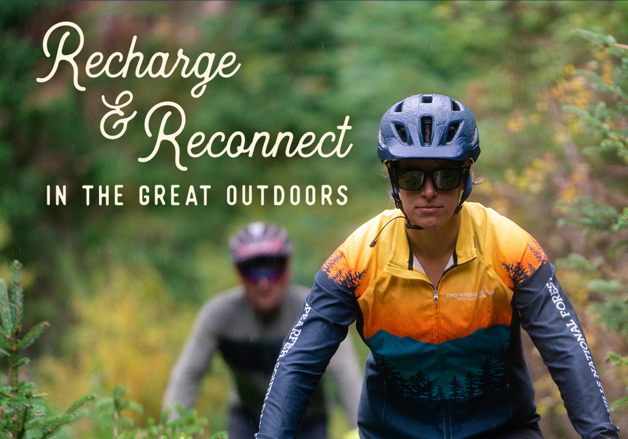 A woman and man mountain-biking through the forest. A headline reads: Recharge & Reconnect in the great outdoors.