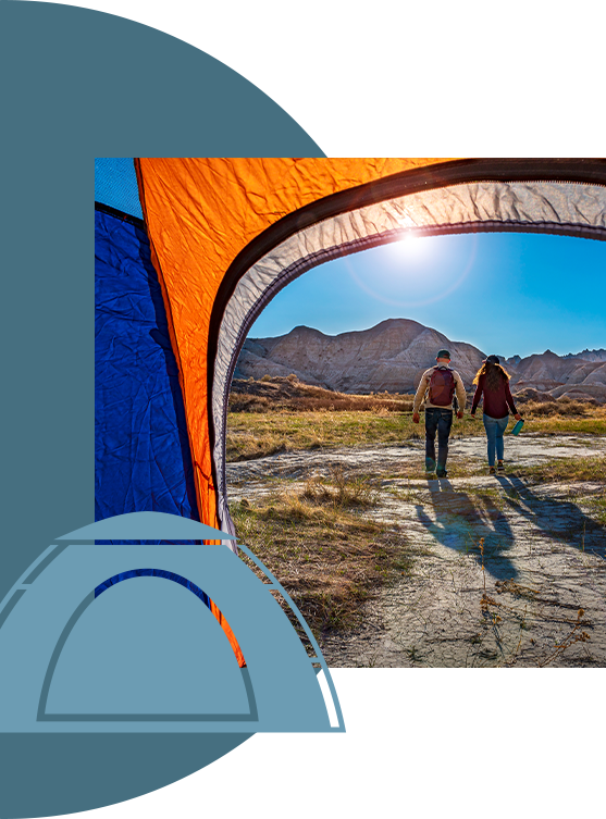 View from the inside of a tent; a couple hiking towards the mountains.