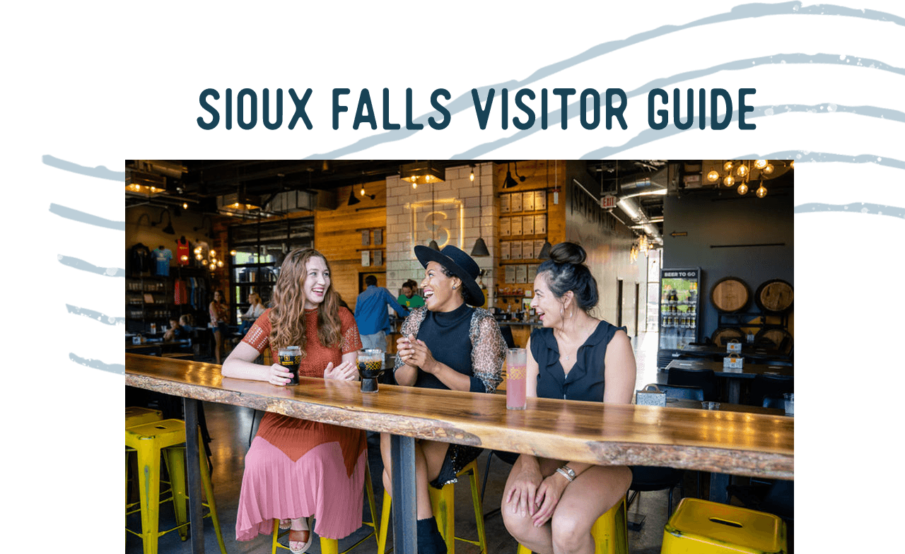 Three women sit at a bar enjoying drinks. A headline reads: Sioux Falls Visitor Guide.