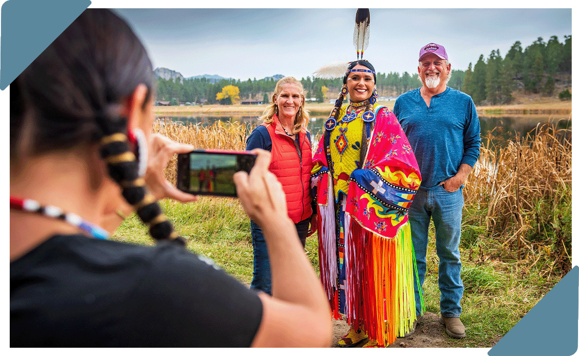 A couple taking a photo with a tribal woman.