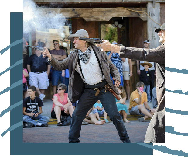 A crowd watching actors in a Wild West show.