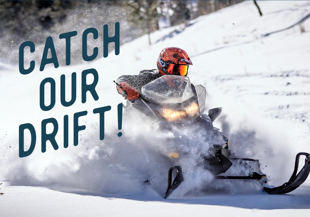 A person riding a snowmobile through white fluffy snow.