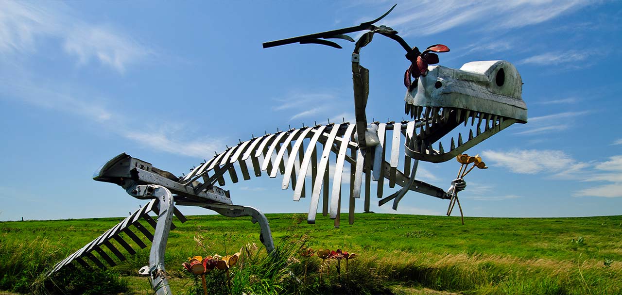 Image of a T-Rex dinosaur sculpture made of metal.